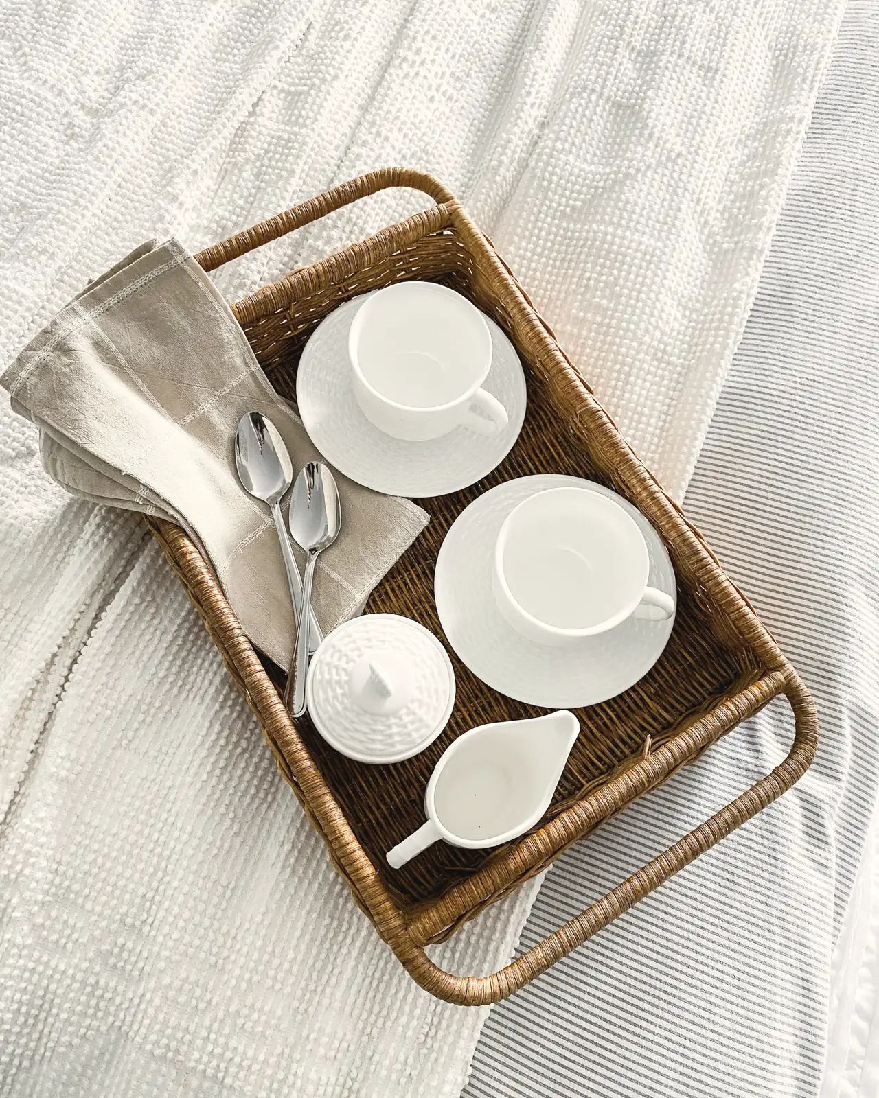 A breakfast tray, white cups on linen