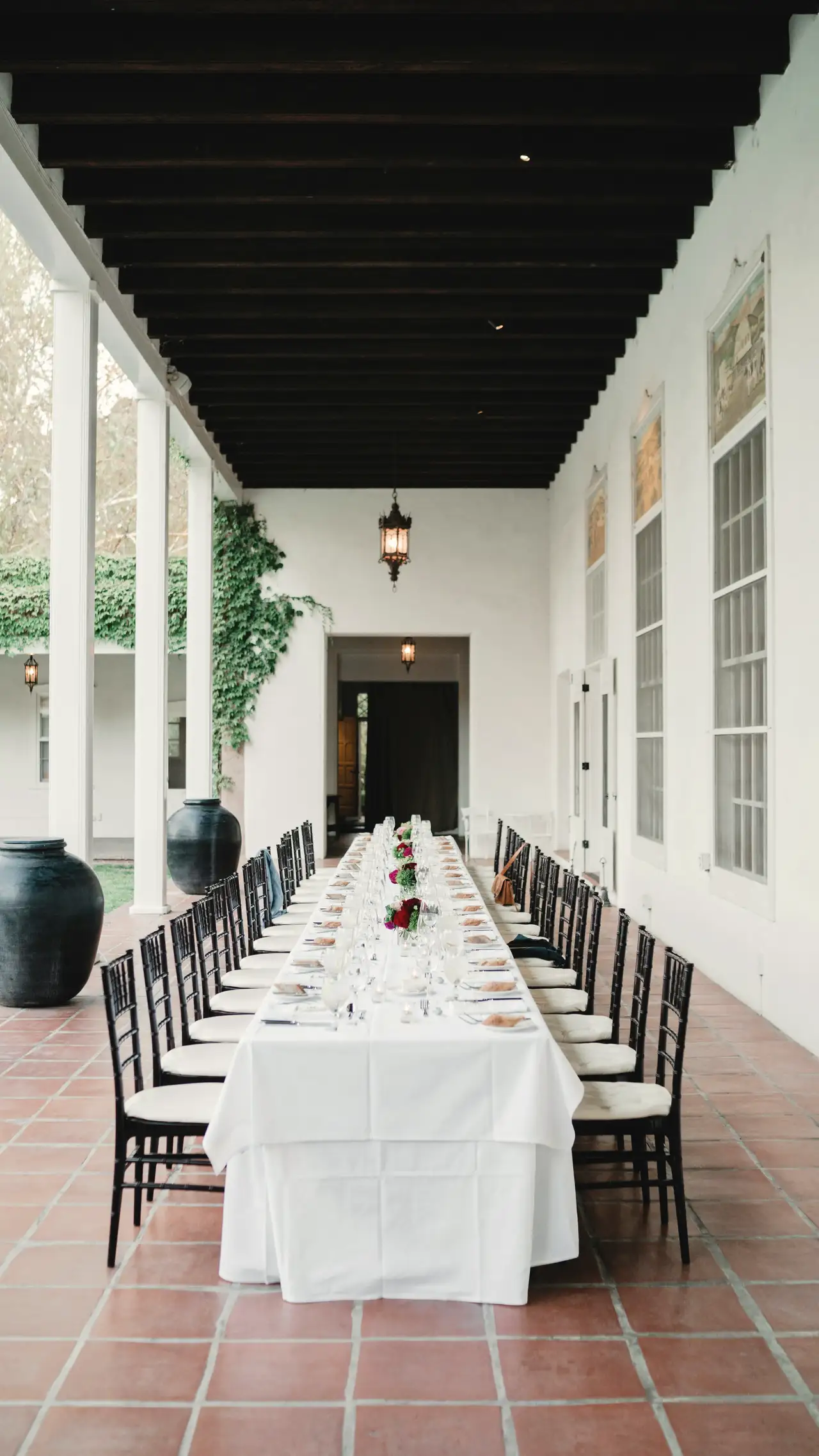 The long table under the arcade, laid for the evening