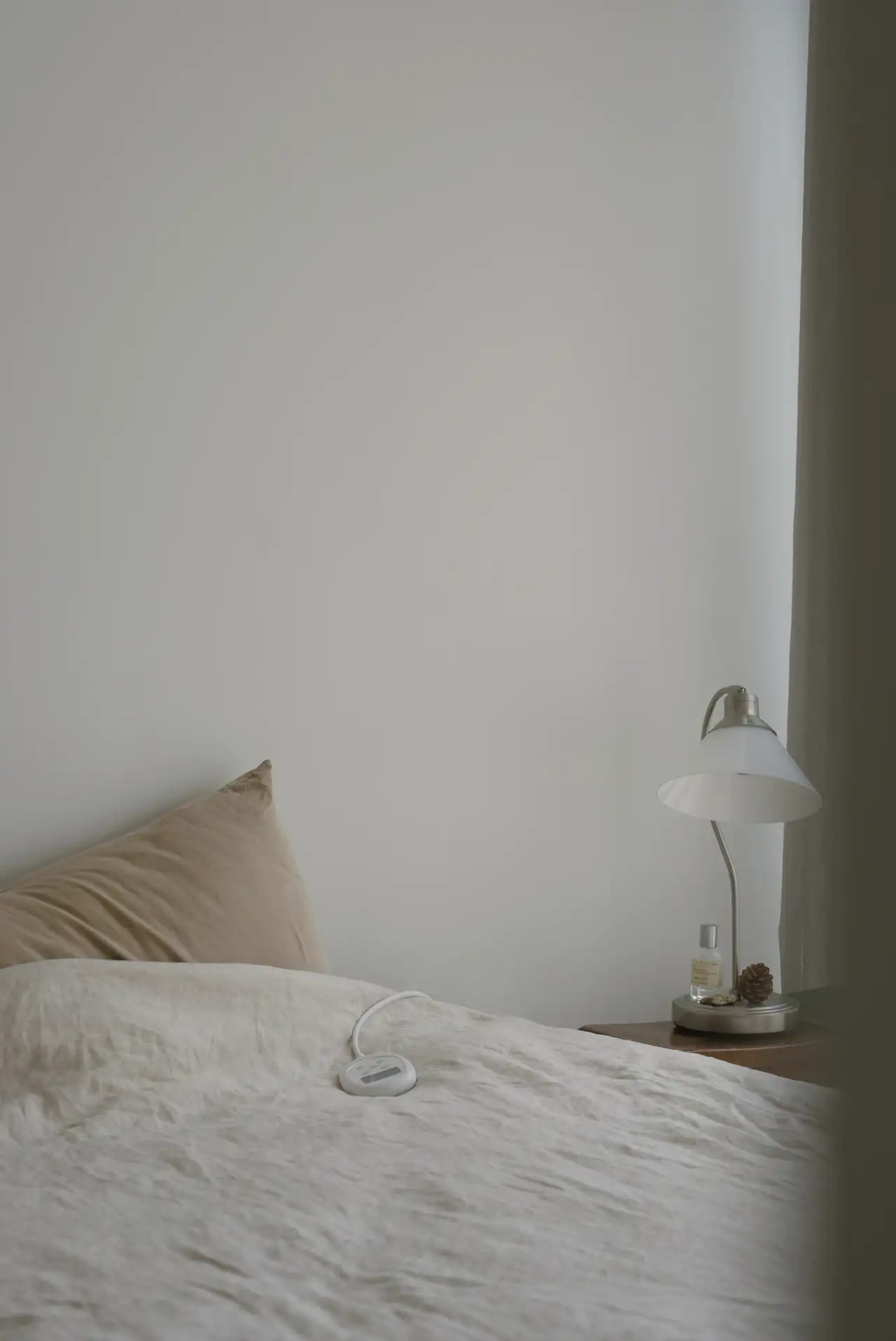 The corner of a bed against the white wall
