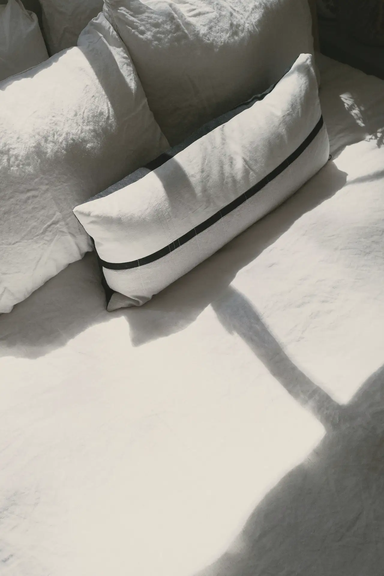 Linen cushions, a sharp shadow of sun